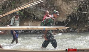 Gendongan Hangat Babinsa Ransiki pada Bocah Papua, Sebrangi Derasnya Sungai Kampung Neney